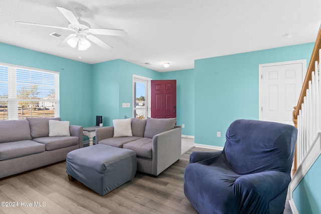 living room with hardwood / wood-style floors, a textured ceiling, and ceiling fan