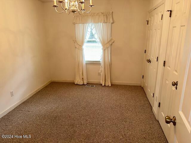 1738 NC-306 Hwy S, Grantsboro, NC 28529 - carpeted empty room with a chandelier and baseboards