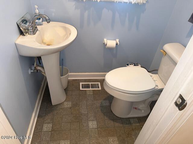 1738 NC-306 Hwy S, Grantsboro, NC 28529 - bathroom featuring baseboards, toilet, and stone finish floors