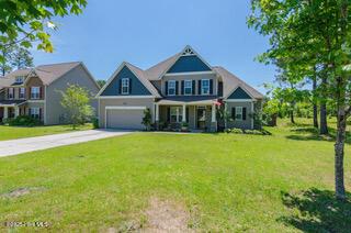 craftsman house featuring a porch, a garage, a front lawn, and central air condition unit