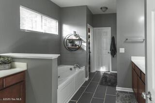 bathroom featuring vanity and a bath