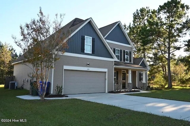 craftsman house with cooling unit, a garage, and a front lawn