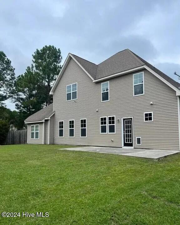 back of house featuring a lawn and a patio