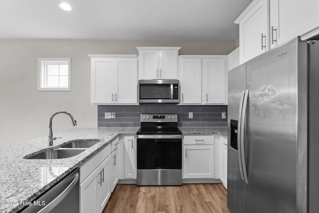 kitchen featuring hardwood / wood-style floors, stainless steel appliances, white cabinetry, and sink