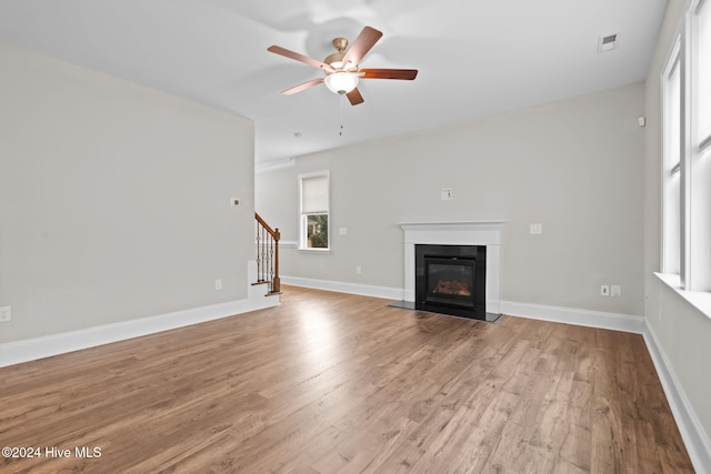 unfurnished living room featuring ceiling fan and light hardwood / wood-style flooring