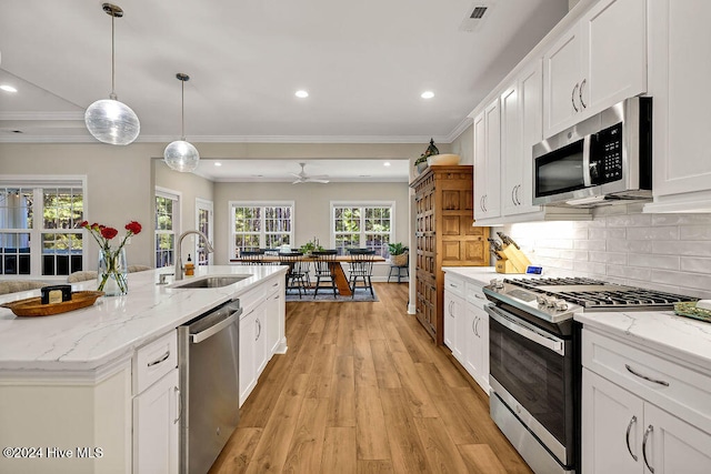 kitchen featuring appliances with stainless steel finishes, white cabinetry, and sink