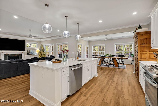 kitchen with sink, light hardwood / wood-style flooring, an island with sink, white cabinetry, and stainless steel appliances