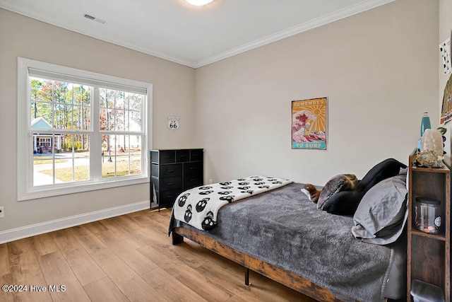 bedroom with light wood-type flooring and ornamental molding