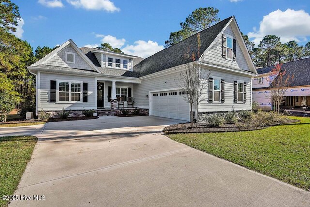 view of front of property featuring a front lawn, a porch, and a garage