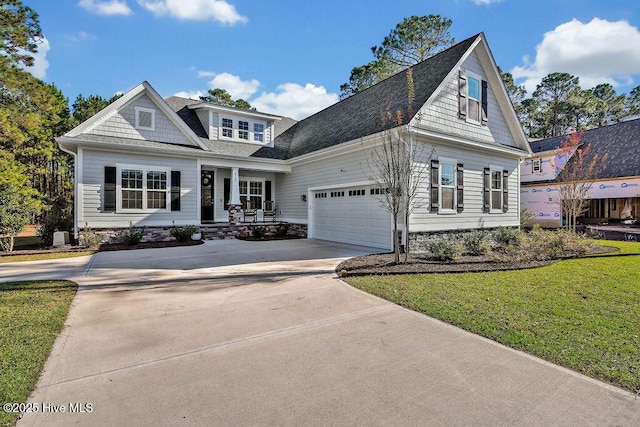 view of front of house with a front yard, an attached garage, covered porch, and driveway