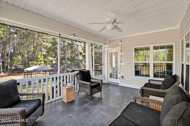 sunroom featuring ceiling fan and wooden ceiling