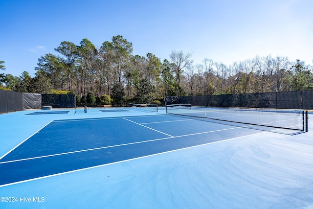 view of tennis court featuring basketball hoop