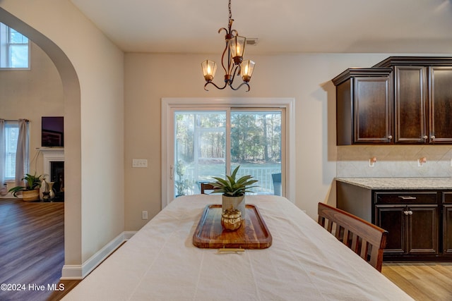 270 Hydrangea Ln, Hampstead, NC 28443 - dining space with arched walkways, wood finished floors, a chandelier, and a fireplace