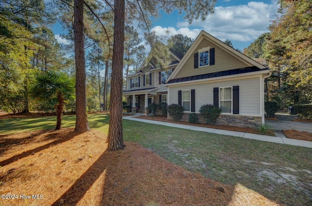 270 Hydrangea Ln, Hampstead, NC 28443 - craftsman-style home featuring a standing seam roof, stone siding, a front yard, and metal roof