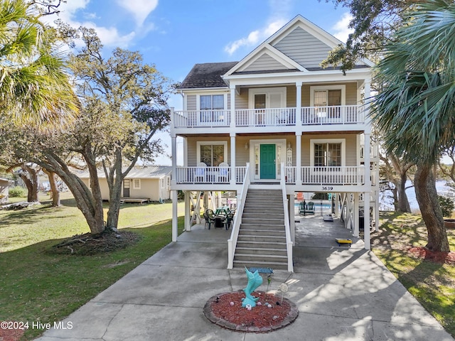 coastal home with a carport, a porch, and a front yard