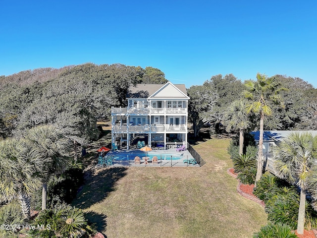 back of property featuring a lawn, a balcony, and a patio