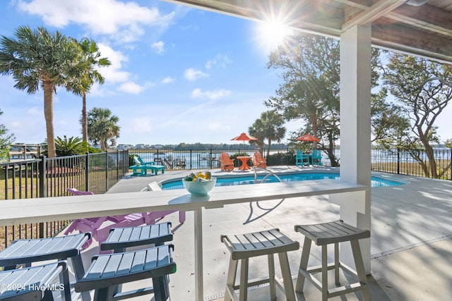 view of swimming pool with a patio and a water view