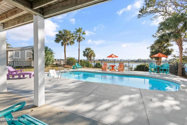 view of pool with a water view and a patio