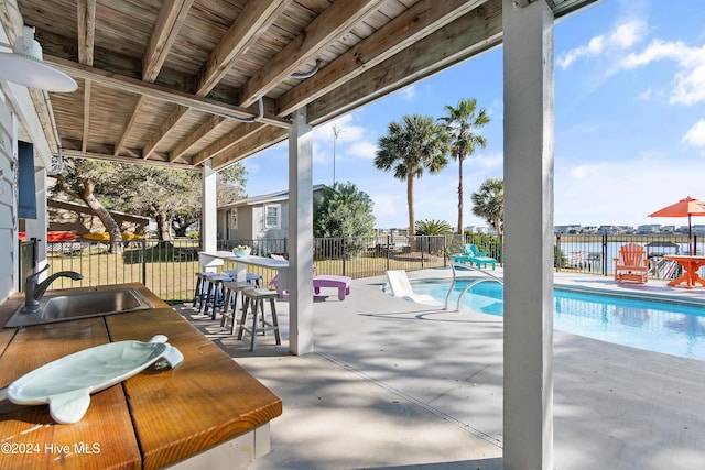 view of patio / terrace with a fenced in pool and sink