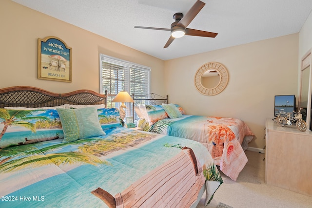 bedroom featuring ceiling fan, carpet floors, and a textured ceiling