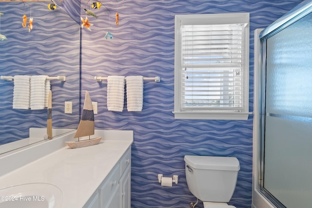 bathroom with plenty of natural light, toilet, and a shower with door