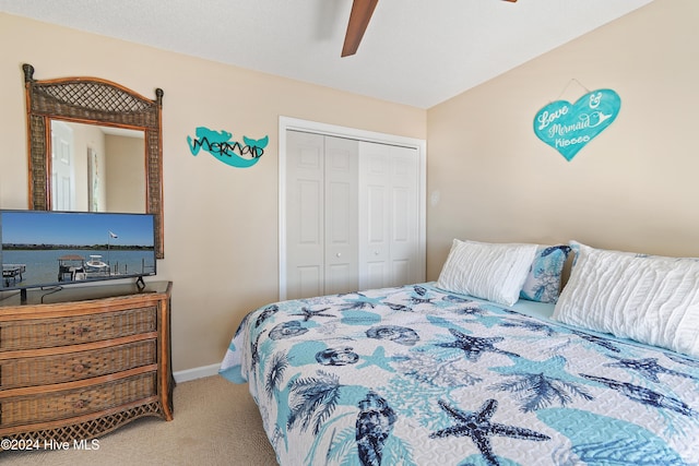 carpeted bedroom with ceiling fan and a closet