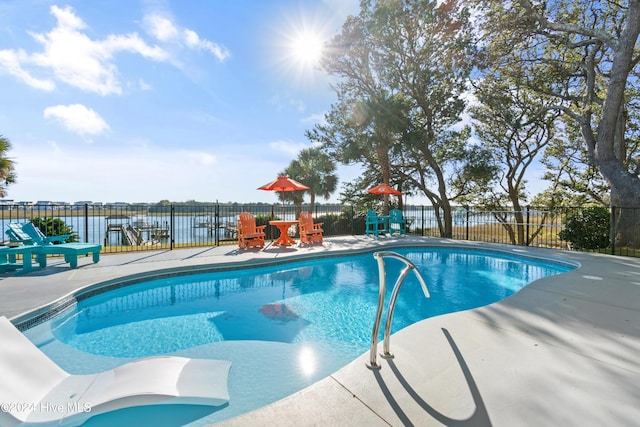 view of swimming pool featuring a patio and a water view