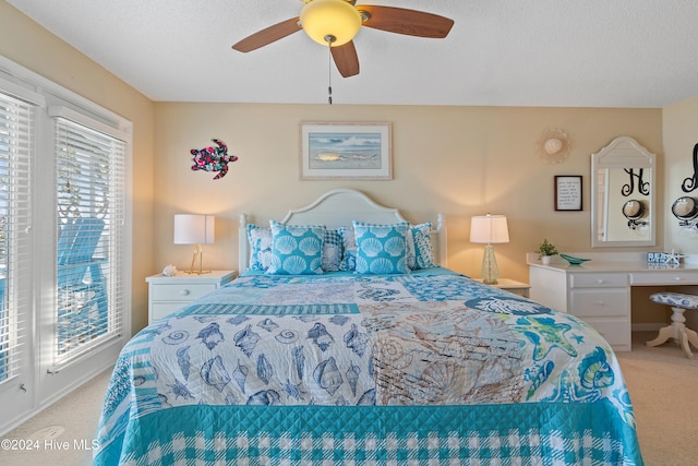 carpeted bedroom featuring multiple windows, ceiling fan, and a textured ceiling