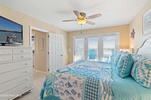 carpeted bedroom with ceiling fan and a textured ceiling