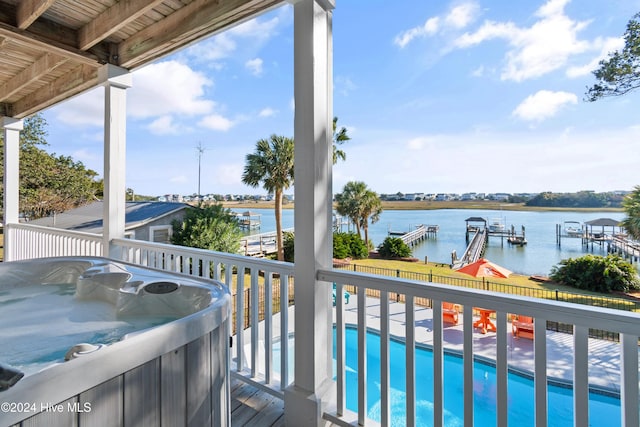 balcony featuring a dock, a water view, and a hot tub