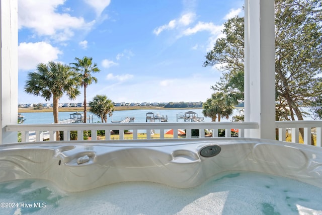 view of pool featuring a water view and a hot tub