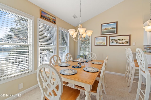 carpeted dining space with an inviting chandelier and lofted ceiling