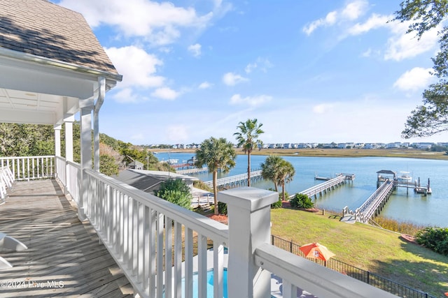 wooden deck featuring a boat dock, a water view, and a yard