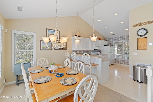 dining area with light carpet, an inviting chandelier, and lofted ceiling