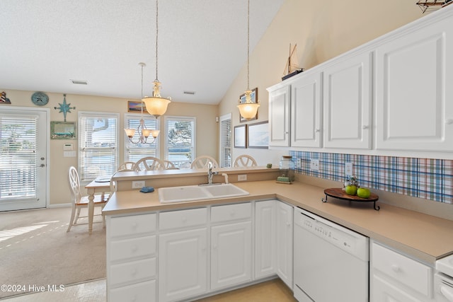 kitchen with dishwasher, sink, hanging light fixtures, kitchen peninsula, and lofted ceiling