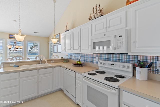 kitchen with white appliances, decorative light fixtures, and white cabinetry