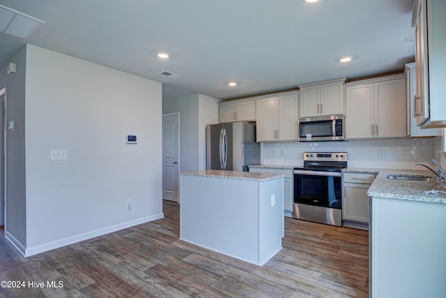 kitchen with dark wood-type flooring, a center island, stainless steel appliances, and sink