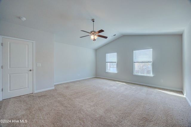 carpeted spare room with vaulted ceiling and ceiling fan