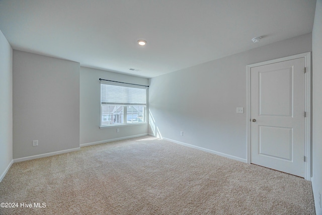 spare room featuring light carpet