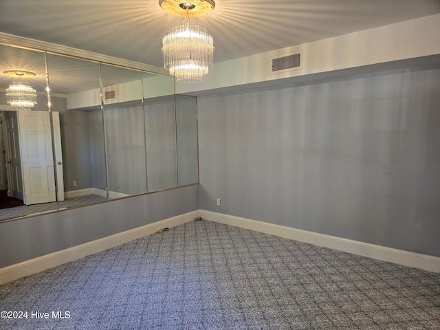 unfurnished room featuring crown molding, carpet floors, and a chandelier