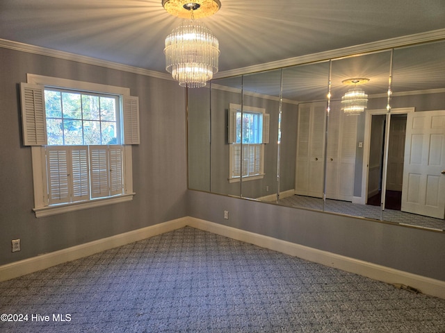 carpeted empty room featuring crown molding and a notable chandelier