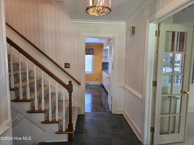 foyer featuring a chandelier and crown molding