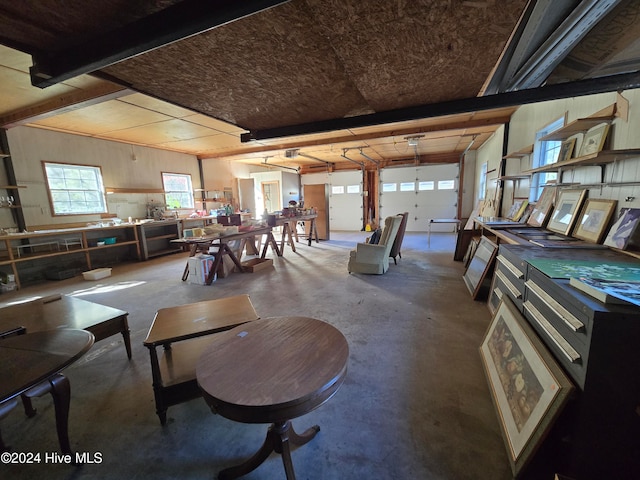 dining space featuring beamed ceiling and concrete floors