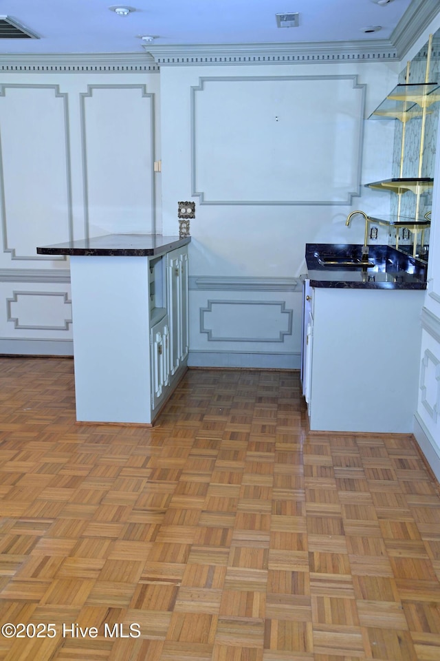 1112 Laurel Ln NW, Wilson, NC 27896 - kitchen with dark countertops, white cabinets, and a sink