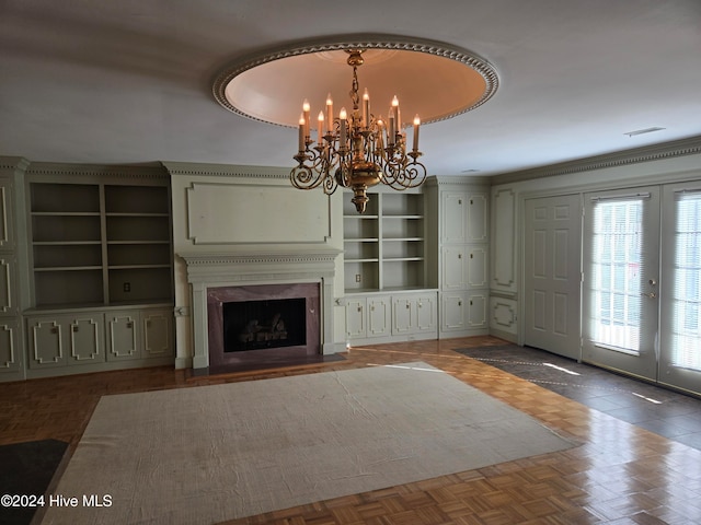 unfurnished living room featuring french doors, dark parquet floors, crown molding, a notable chandelier, and a fireplace