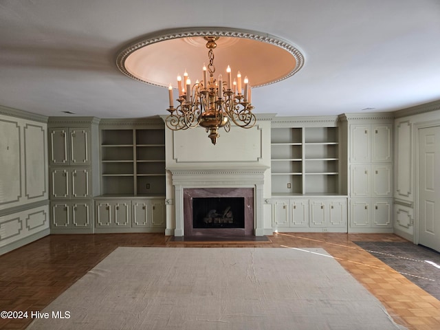 unfurnished living room with dark parquet flooring, built in features, a notable chandelier, and a premium fireplace