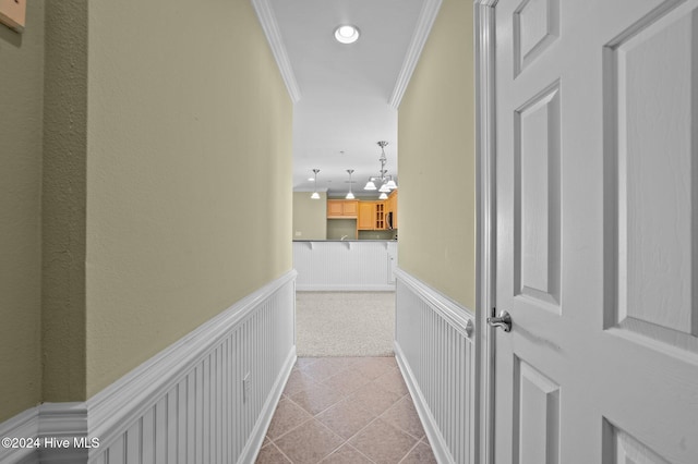 hall with crown molding and light colored carpet