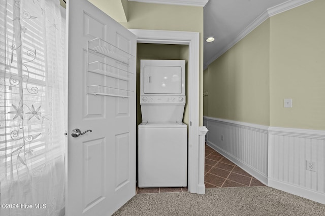 laundry room featuring carpet floors, stacked washer and dryer, and crown molding