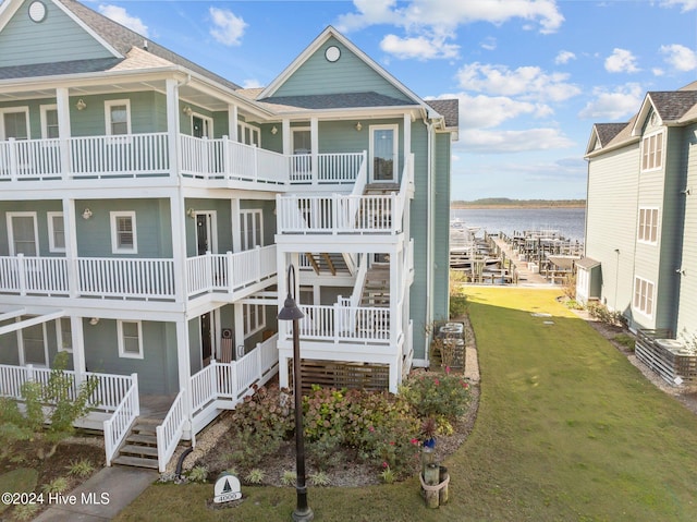 view of front of home with a water view and a front lawn