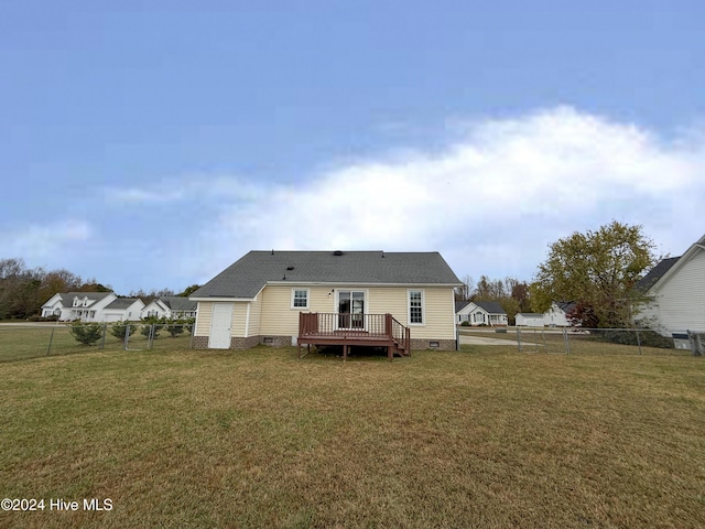 back of property featuring a wooden deck and a yard